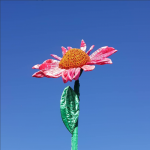 a large flower make of a shiny texture fabric points up in a blue sky